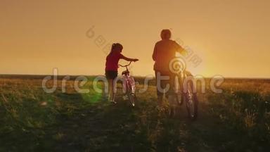 几代人的交流。 祖母和孙女在日落时一起去，开自行车。